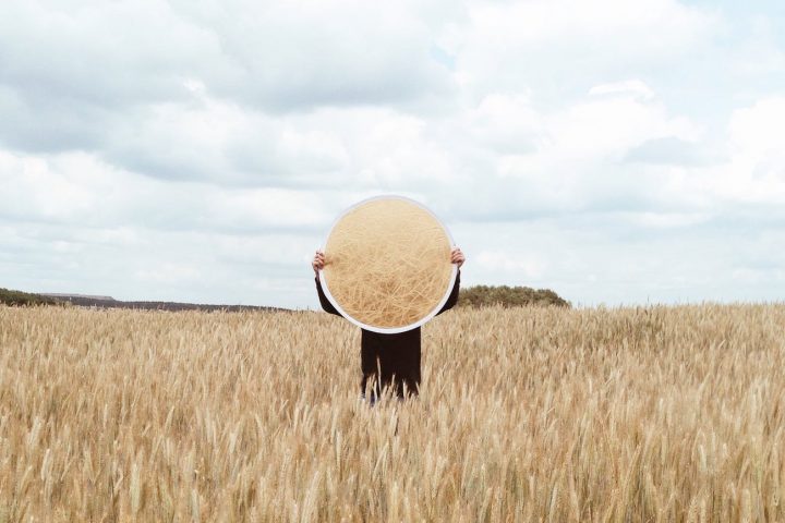 person holding a mirror on an open field