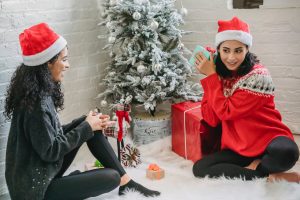 ethnic women exchanging presents for christmas holidays