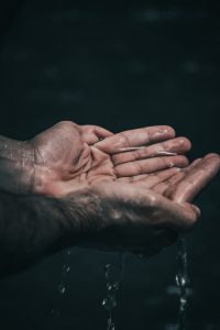 person holding water in cupped hands