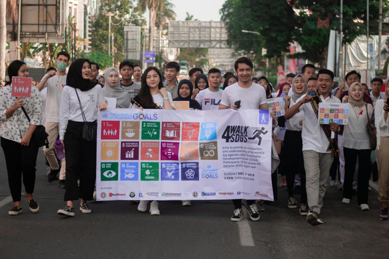 group of people holding white banner